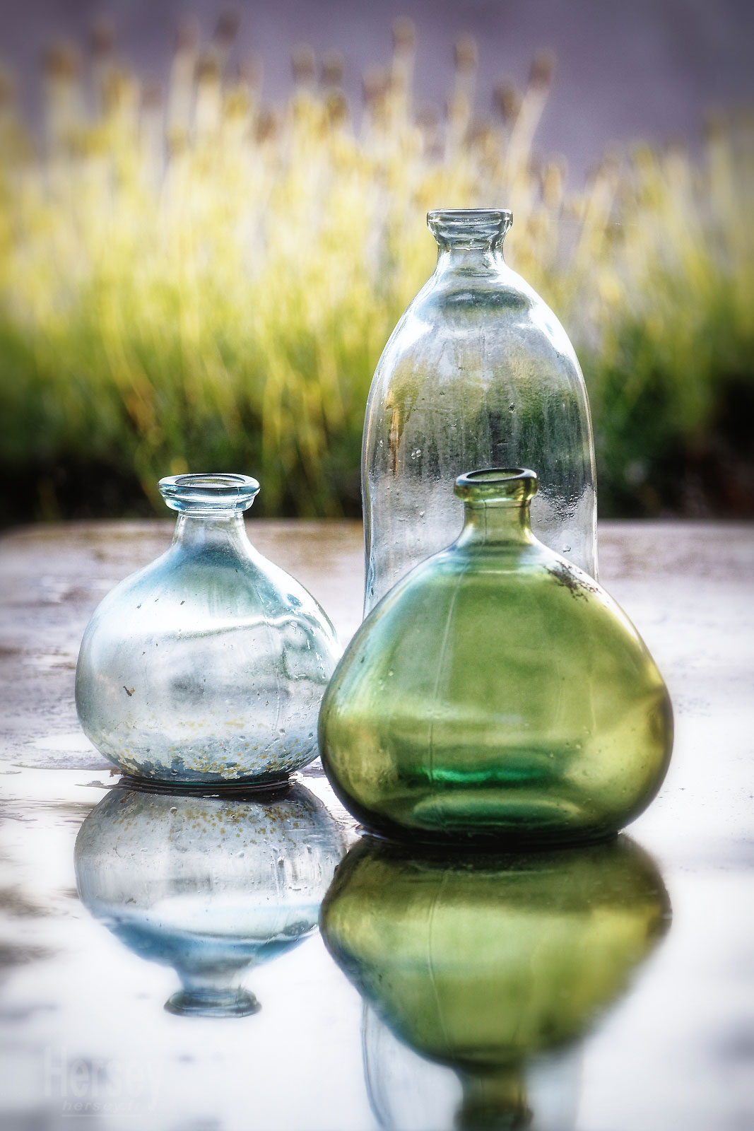 Vases en verre de différentes taille sur une table mouillée © Hersey Photographe